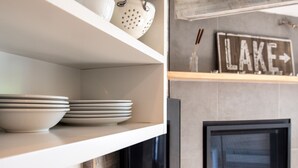 Una estantería de cocina con platos apilados y un colador.