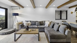 Un soggiorno moderno con un divano grigio, un tavolino in legno e una lampada da terra.