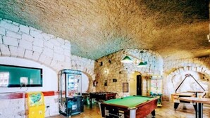 A billiards room with stone walls and a pool table. - Bib's Pool Side Apartment & Ocean View (CN)