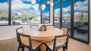 A dining area with a round table, six chairs, and a modern chandelier. - 5 Min to Bald Mountain | Sawtooth Views (Ketchum)