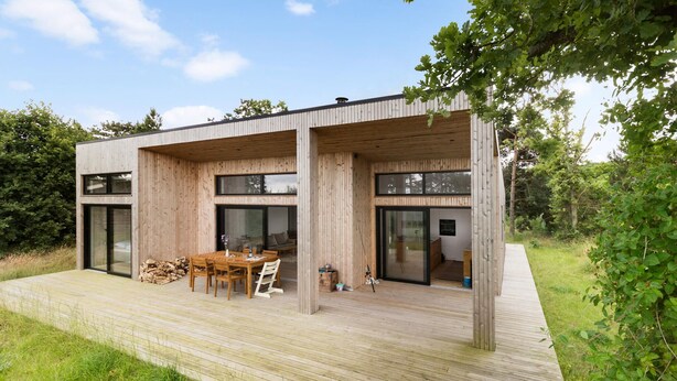 A modern wooden house with a deck, large windows, and a dining area. - 3 bedroom pet friendly home in Glesborg (Glesborg)