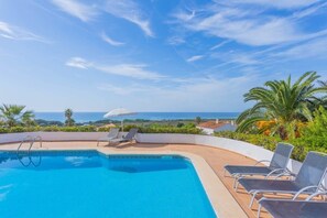 A swimming pool with lounge chairs and a view of the ocean. - Villa Sol A - Stunning beaches and relaxed Mediterranean atmosphere (San Jaime Mediterráneo)