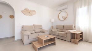 Una sala de estar moderna con dos sofás, una mesa de centro y una lámpara de pie.