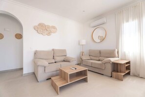 A modern living room with two sofas, a coffee table, and a floor lamp.
