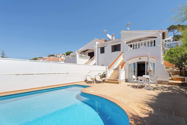 A white building with a swimming pool, outdoor seating, and a staircase leading to a balcony. - Villa Paloma - Magnificent Sea Views (San Jaime Mediterráneo)