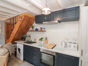 A compact kitchen with dark cabinets, a built-in oven, a microwave, and a toaster. - Rose Lea (Saltburn-by-the-Sea)