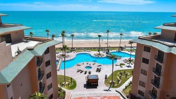 A resort with a central pool, beach access, and ocean views.