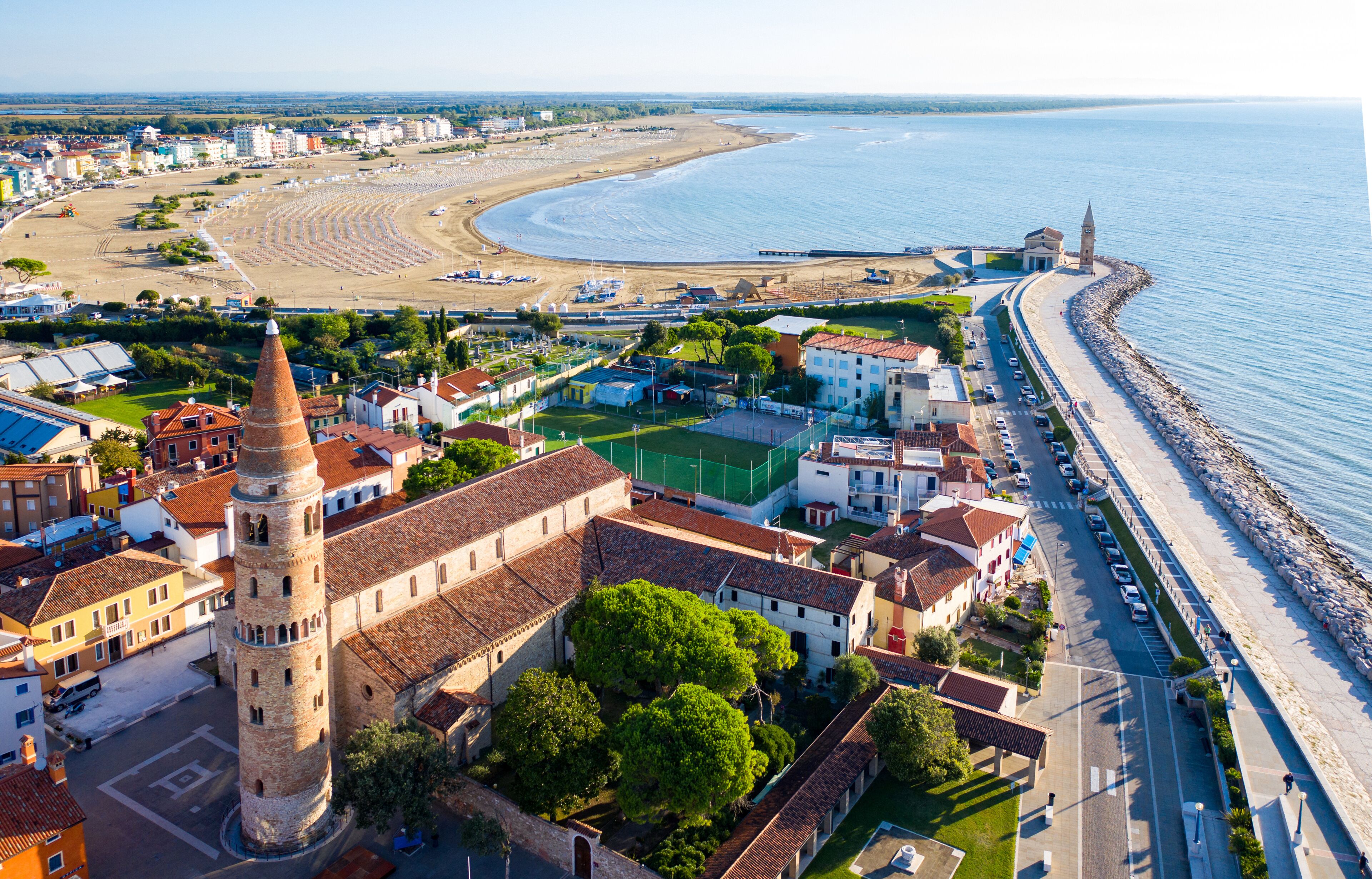 Une ville côtière dotée d’une tour imposante, d’une plage et d’une route menant à la mer.