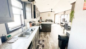 A modern kitchen with a central island, a dining area, and a living space. - Adventure Await! 20minute to Abraham Lake Ice Bubbles, Full home+ Mountain views (Nordegg)