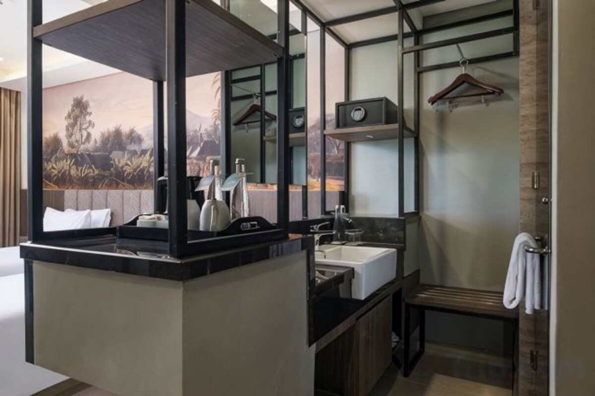 Un baño moderno con un espejo grande, un lavabo y una zona de ducha.