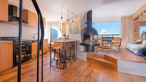 Eine moderne Küche mit großem Herd, Holzboden und einer Essecke mit Hockern.
