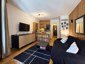 A compact living space with a kitchenette, a dining area, and a seating area with a sofa and a coffee table. - Mountain studio, ski-in/ski-out, balcony, 4 pers (Les Orres)