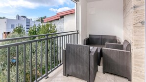 A balcony with wicker furniture, a metal railing, and a view of buildings and trees. - 3 bedroom awesome apartment in Vir (Vir)