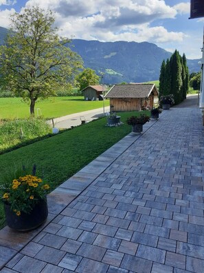 Guests can stroll along the pathway to this traditional guesthouse, surrounded by lush greenery and rolling hills.