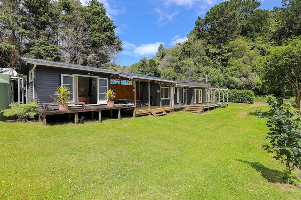 A row of cabins with wooden decks and a grassy yard.