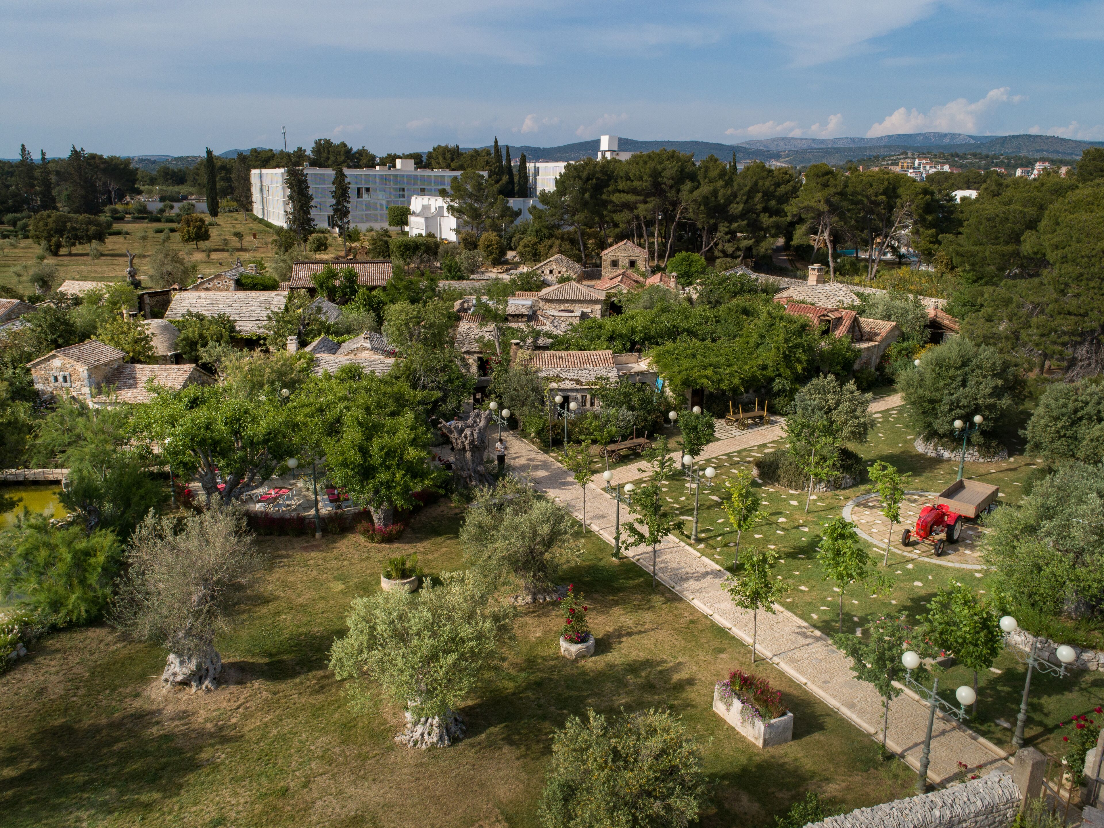 A village with traditional stone buildings, narrow pathways, and lush greenery.