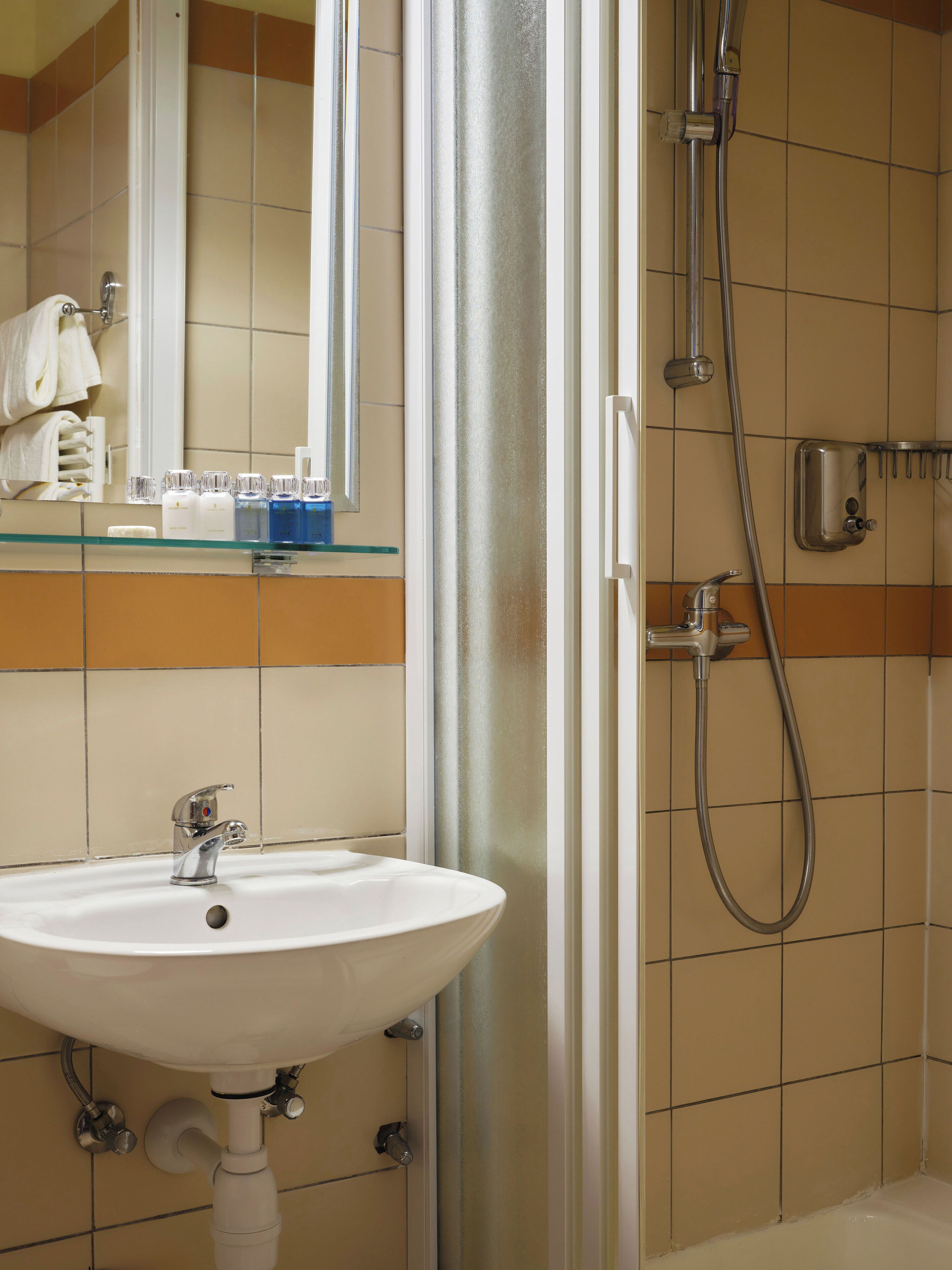 Un baño con lavamanos, espejo y ducha.