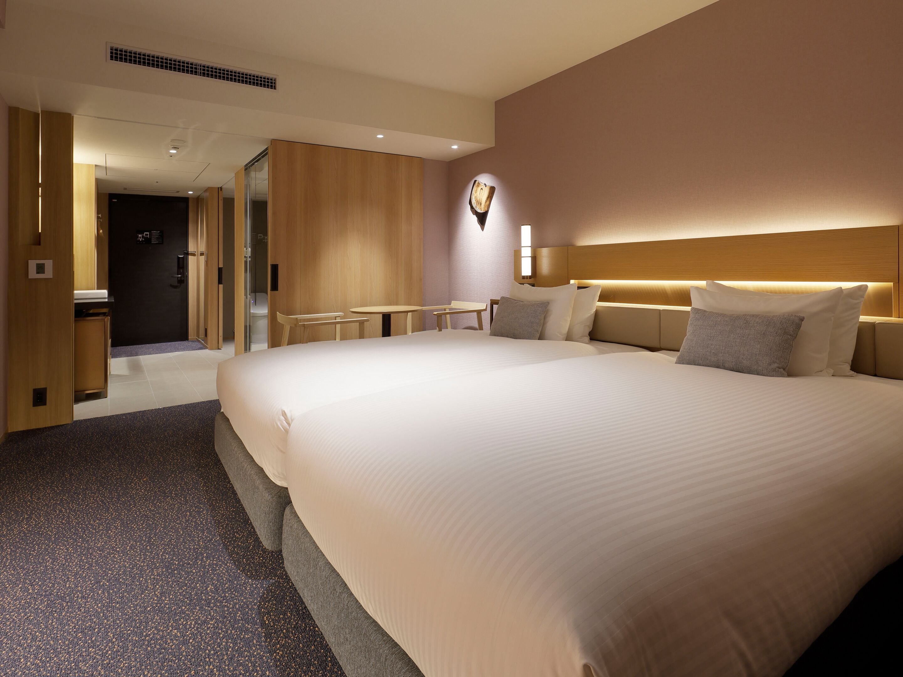 Une chambre d’hôtel avec un grand lit, des tables de chevet, un bureau et une chaise.