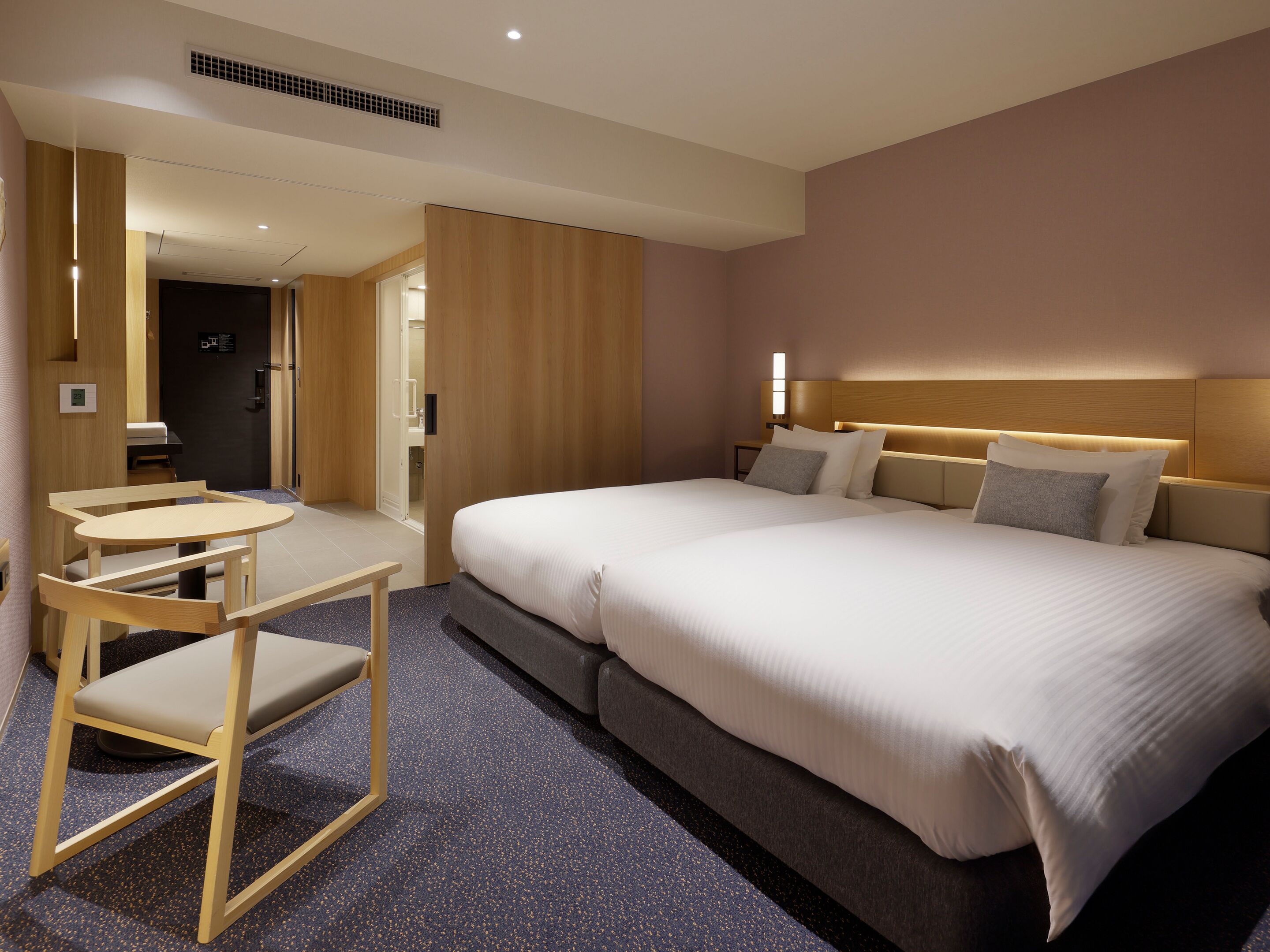 Una habitación de hotel con una cama, un escritorio y una silla.