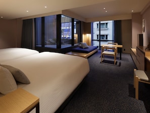 A hotel room with a large bed, a seating area with a table, and a view of the cityscape through large windows. - Mitsui Garden Hotel Kyoto Sanjo PREMIER (Kyoto)