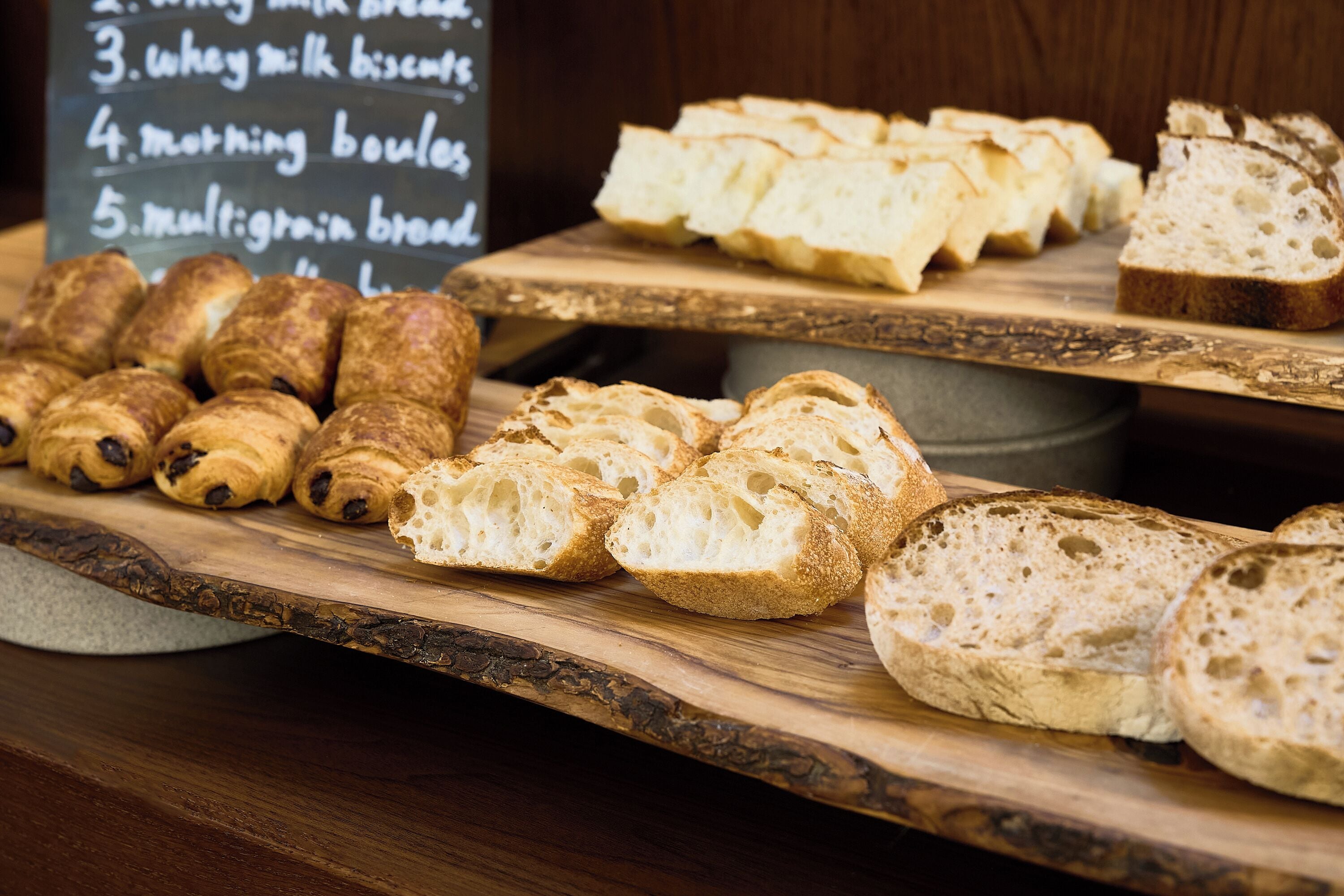 A variety of breads displayed on wooden boards.
