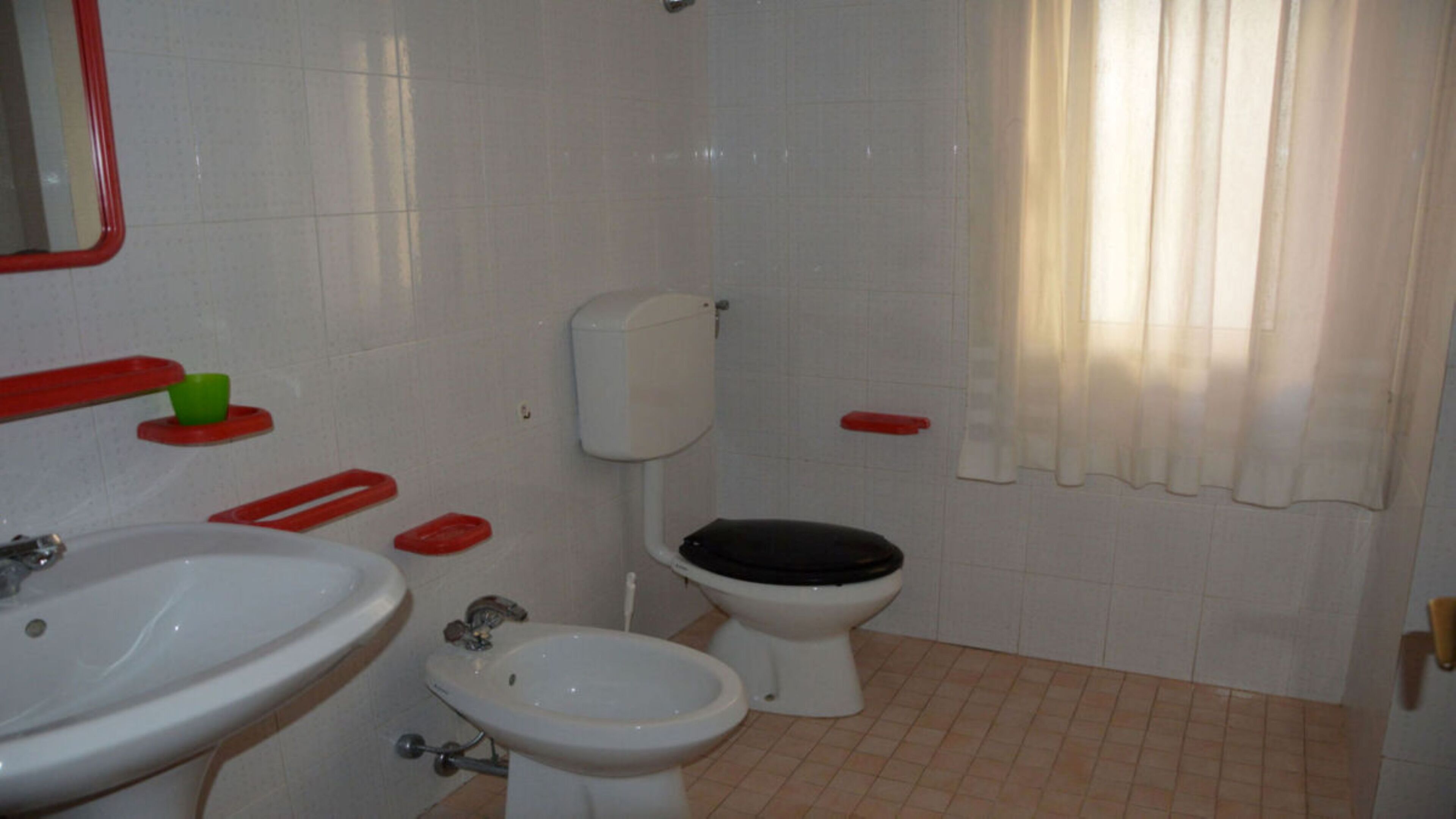 Et badeværelse med toilet, bidet og håndvask.