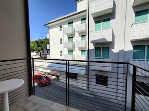 Un balcone con vista su un edificio con numerosi balconi e finestre.