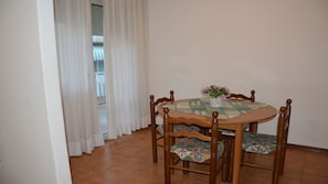 Une table à manger avec des chaises, un chemin de table et une plante en pot.