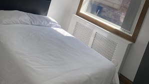 Une chambre avec un grand lit, une fenêtre donnant sur un beau paysage et un luminaire décoratif au plafond.