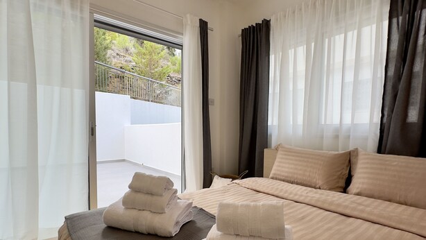 Een hotelkamer met een bed, balkon en uitzicht.