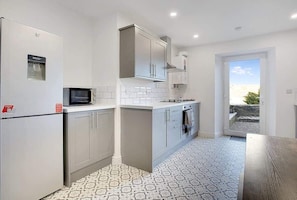 A modern kitchen with a built-in microwave, stainless steel cabinets, and a tiled backsplash.
