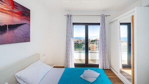 A hotel room with a bed, a view of the city, and a balcony with curtains. - Deluxe Villa Laura 6a (Novalja)