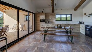 Eine moderne Küche mit Holzausstattung, einem großen Fenster und einem Essbereich mit Bänken.