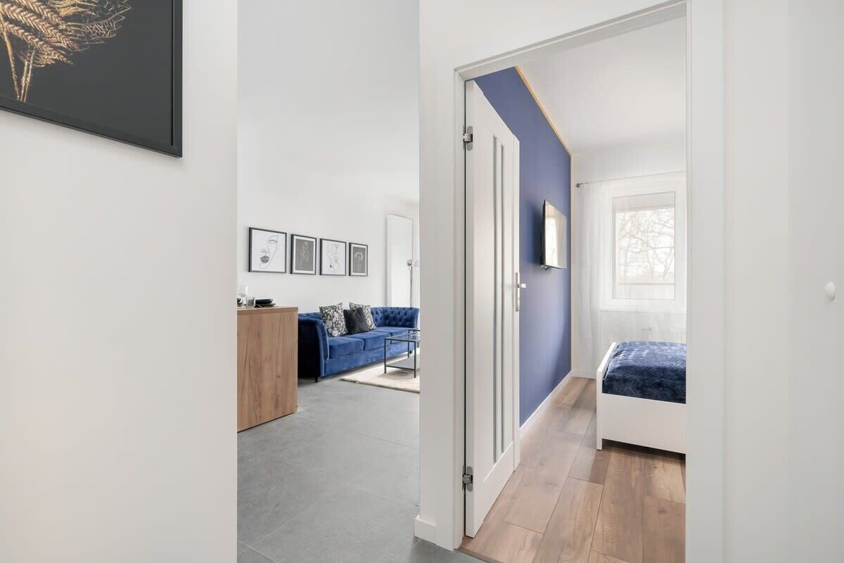 A modern apartment with a living area, a kitchen, and a bedroom.