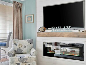 Sink into this comfy chair and let your cares melt away. With a large TV for entertainment and a cozy electric fireplace to set the mood, this living space invites you to truly relax.