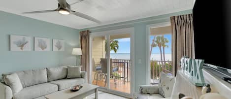 Unwind in your coastal living space where soft sea breezes drift through and palm trees frame your perfect beach escape just beyond the balcony doors.