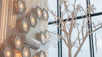 A modern interior with hexagonal light fixtures and a decorative tree with snowflakes.