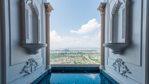 Vista desde un balcón con piscina, que da a un paisaje urbano.