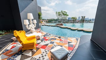 A modern outdoor pool area with a yellow chair, a patterned rug, and a white lamp.