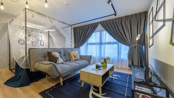 A modern living room with a sofa, coffee table, and a decorative canopy.