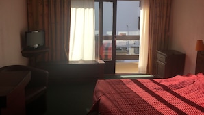 A hotel room with a bed, a TV on a stand, a desk, and a window with curtains. - Appt Résidence Maeva Mont d Arbois (Megève)