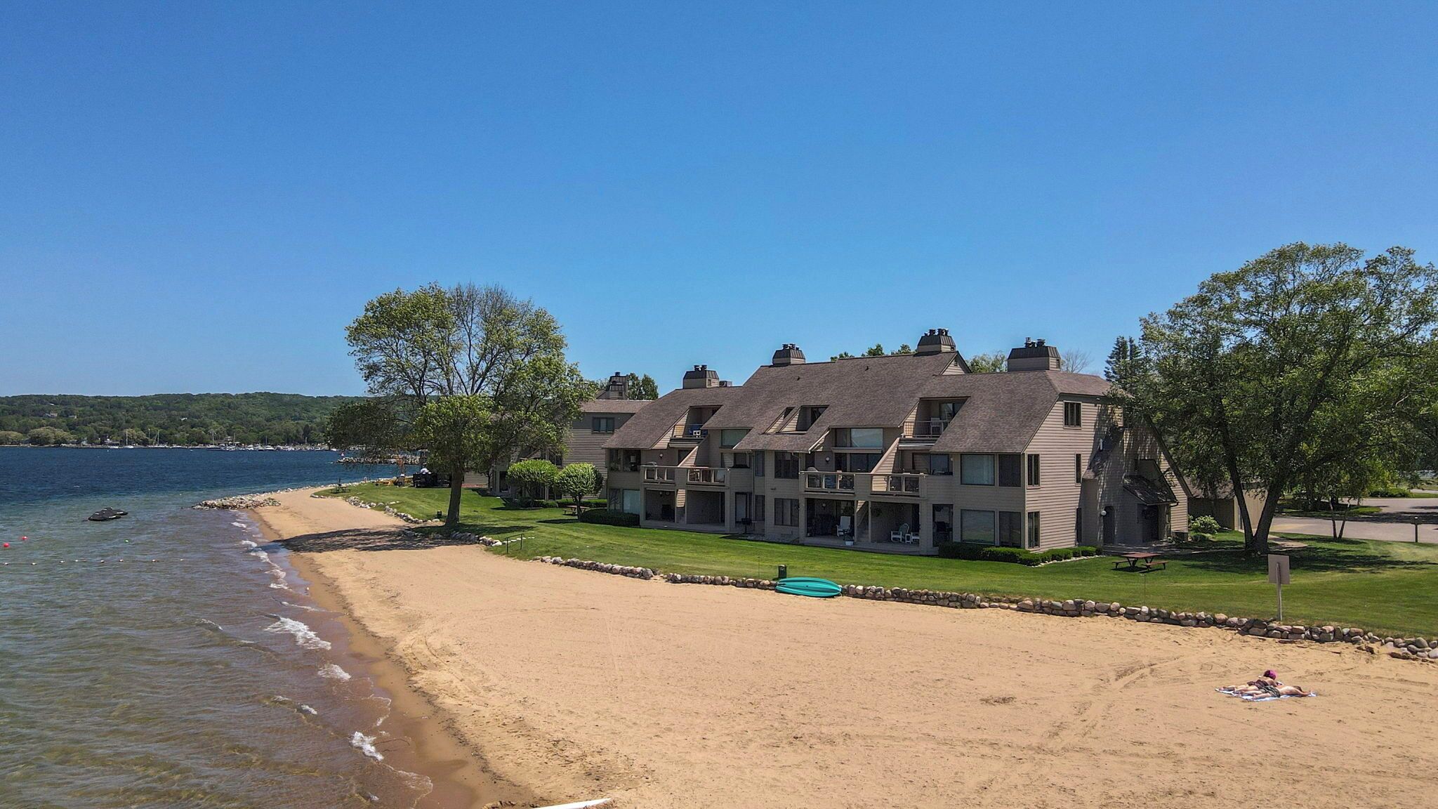 Ein Küstenhotel mit mehreren Gebäuden, einem Sandstrand und Meerblick.