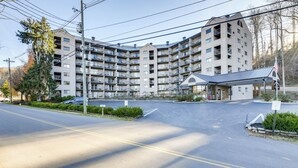 Un edificio residencial de varios pisos con un patio central, balcones y un pequeño anexo con un acceso cubierto.
