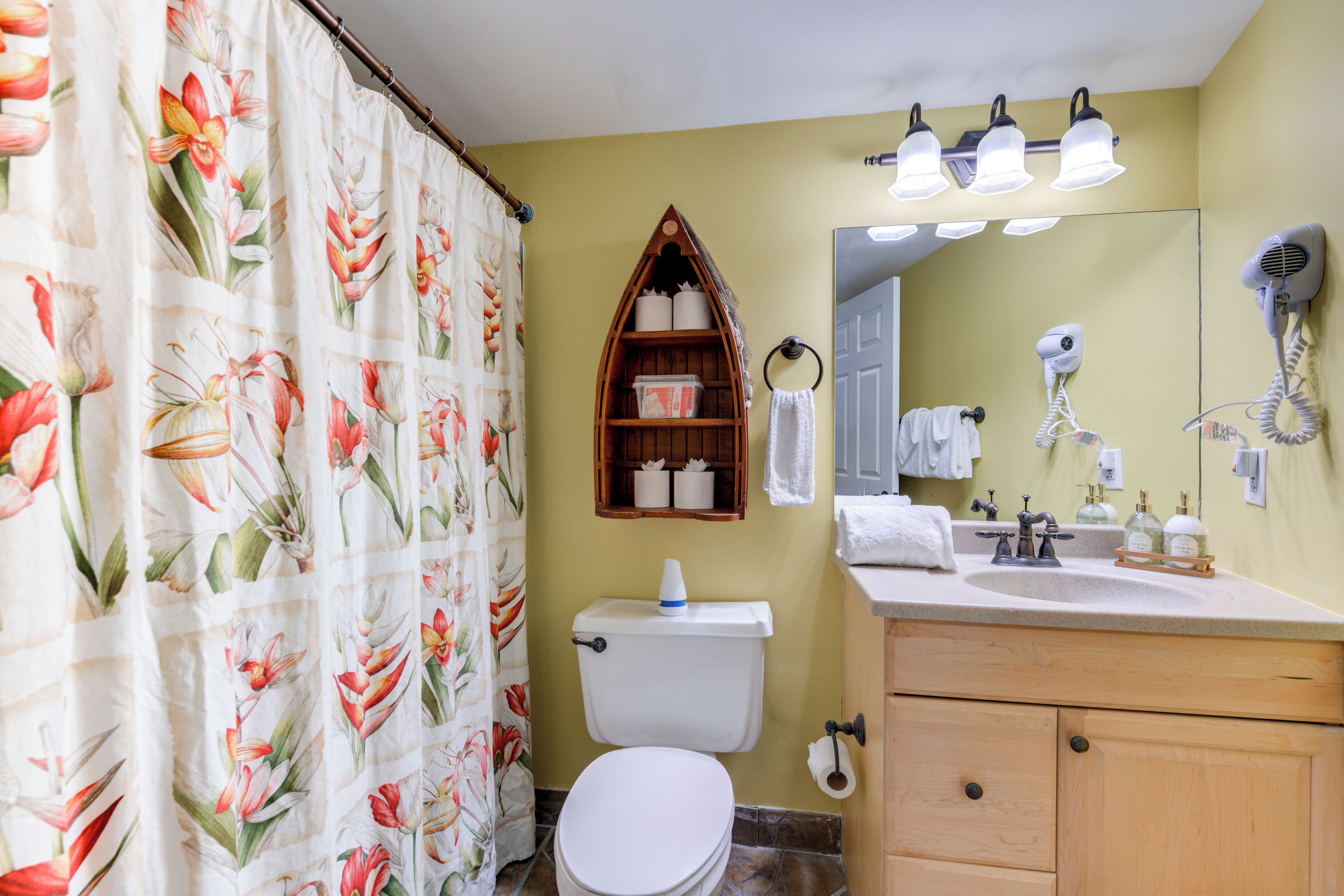 A bathroom with a toilet, sink, and shower curtain.
