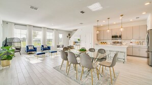 A modern kitchen with a central island, stainless steel appliances, and pendant lighting. - Stylish Four Corners Townhome w/ Resort Amenities (Davenport)