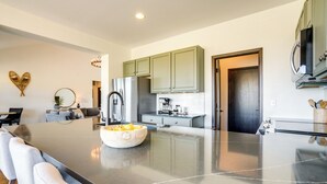 A modern kitchen with a large island, stainless steel appliances, and light green cabinets. - Half-mi to Skiing: Gorgeous Granby Ranch Home! (Granby)