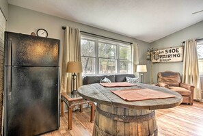 A cozy living room with a wooden coffee table, a sofa, a leather armchair, and a refrigerator. - Studio w/ Patio - Walk to Hikes, Sights & Bites (Aberdeen)