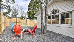 A patio with a table and chairs, a wooden fence, and a house with large windows. - Studio w/ Patio - Walk to Hikes, Sights & Bites (Aberdeen)