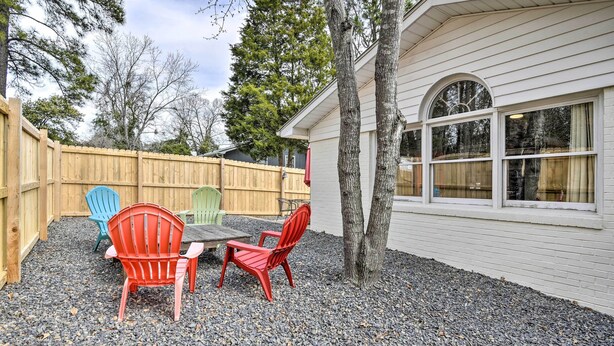 A patio with a table and chairs, a wooden fence, and a house with large windows. - Studio w/ Patio - Walk to Hikes, Sights & Bites (Aberdeen)