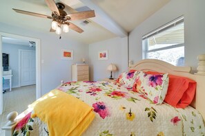 A bedroom with a bed, a ceiling fan, a window, and a door. - Cozy Bandera Cottage w/ Medina River Access! (Bandera)